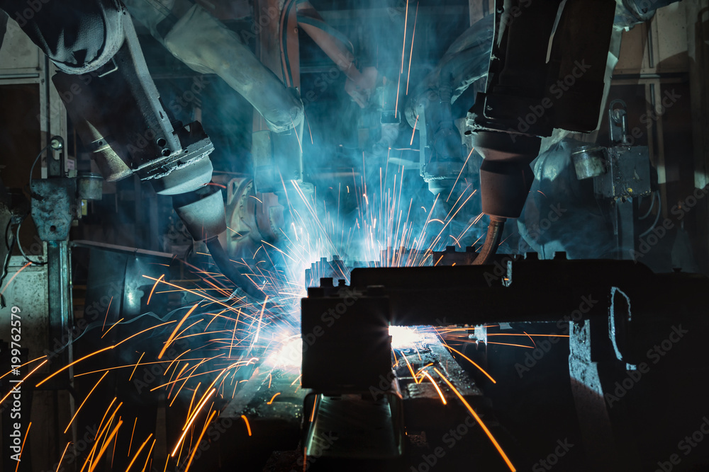 Close up team robots are welding in factory Close up team robots are welding in factory