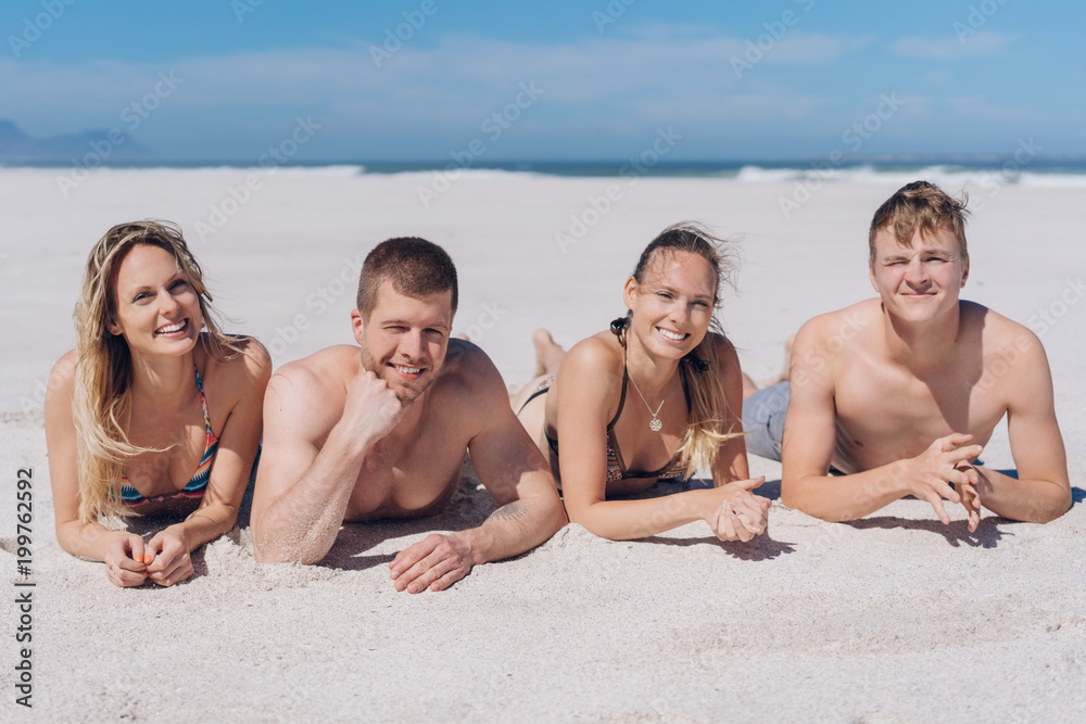 Two attractive young couples relaxing on a beach Two attractive young couples relaxing on a beach