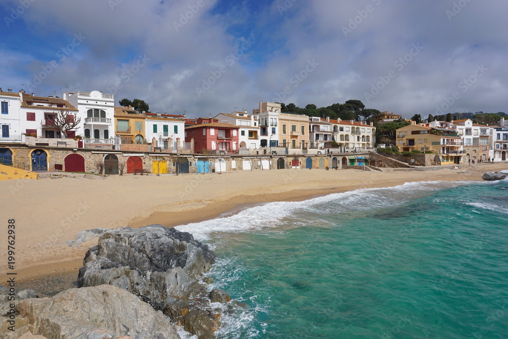 Fototapeta premium Waterfront village Calella de Palafrugell with colored wooden doors of boat storage on the beach, Mediterranean sea, Spain, Costa Brava, Catalonia, Baix Emporda