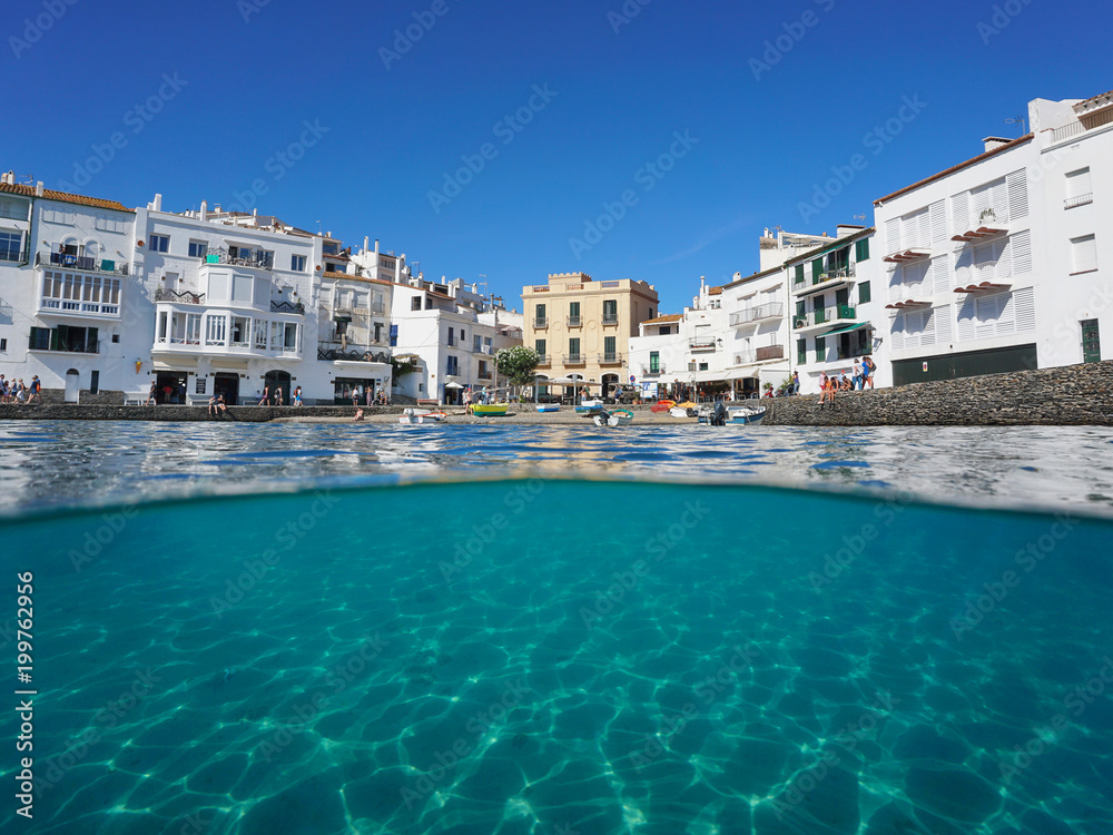 Waterfront village of Cadaques with a small beach and a sandy seabed underwater, split view above and below water surface, Mediterranean sea, Costa Brava, Spain