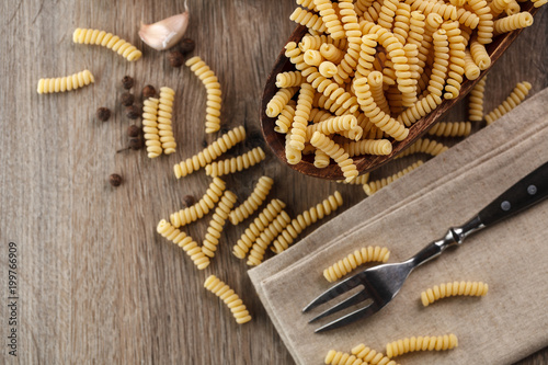 Italian raw pasta fusilli on the background of other ingredients for cooking