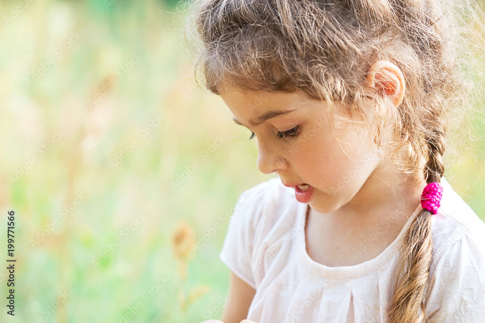 Cute Little girl is playing with on a meadow on a sunny summer day. Cute Little girl is playing with on a meadow on a sunny summer day.