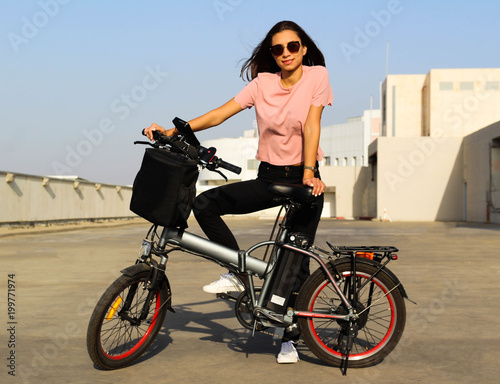 A young woman with an electric bicycle