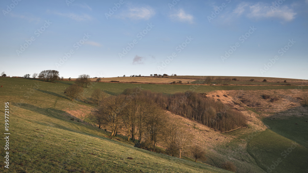 Obraz premium Stunning vibrant sunrise landscape image over English countryside landscape with lovely light hitting the hills