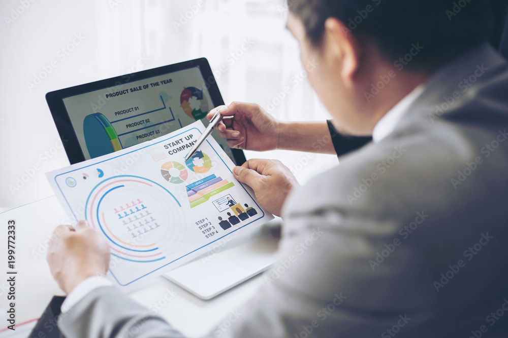 financial Image of two business people pointing at business document during discussion at meeting room , Notebook on wood table - Business concept financial Image of two business people pointing at business document during discussion at meeting room , Notebook on wood table - Business concept