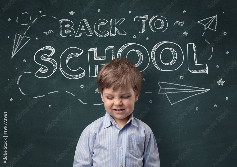 Adorable little boy with blackboard and back to school concept