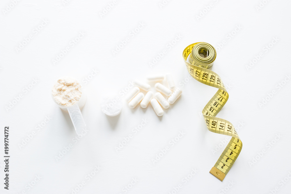 sports supplements protein, bcaa, fat burners and measuring tape concept diet sports supplements protein, bcaa, fat burners and measuring tape concept diet