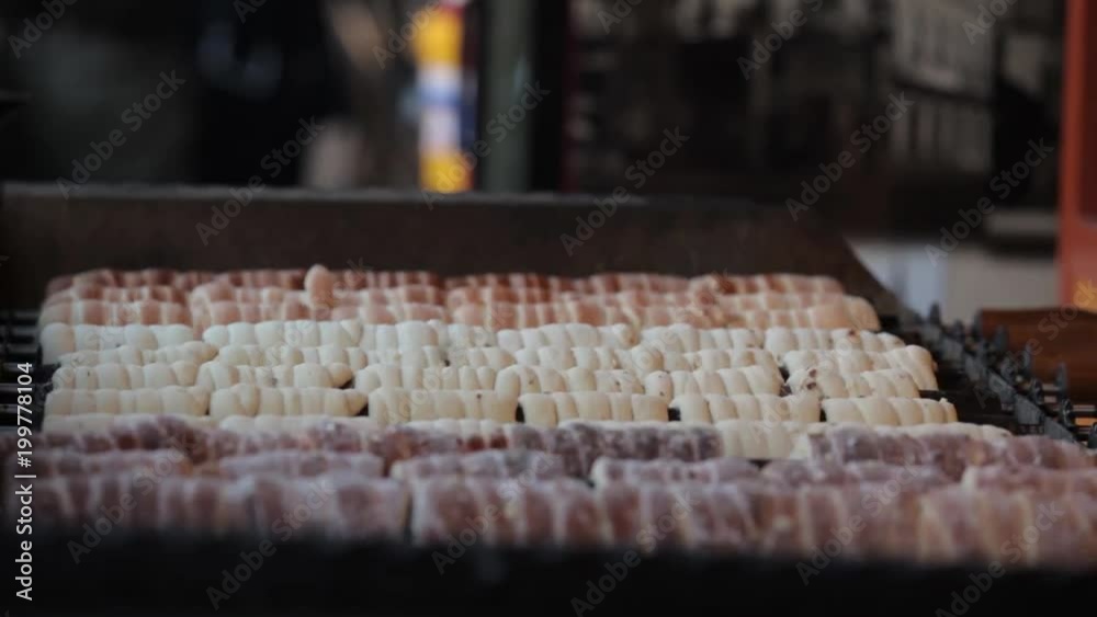 Baking traditional Czech trdelnik on a rotating spits in Prague in evening Baking traditional Czech trdelnik on a rotating spits in Prague in evening