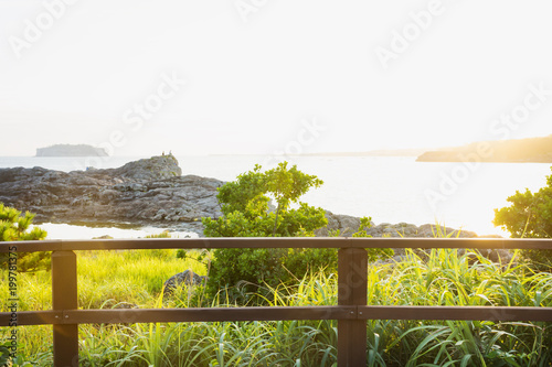 People sitting on cliff watching sunset at Seogwipo, Jeju Island, South Korea photo