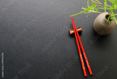 Red chopsticks on black table background Top view