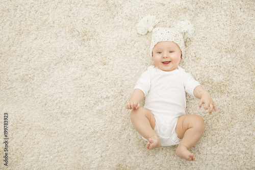 Quadro su tela Happy Baby in Hat and Diaper Lying on Carpet Background, Smiling Infant Kid Boy