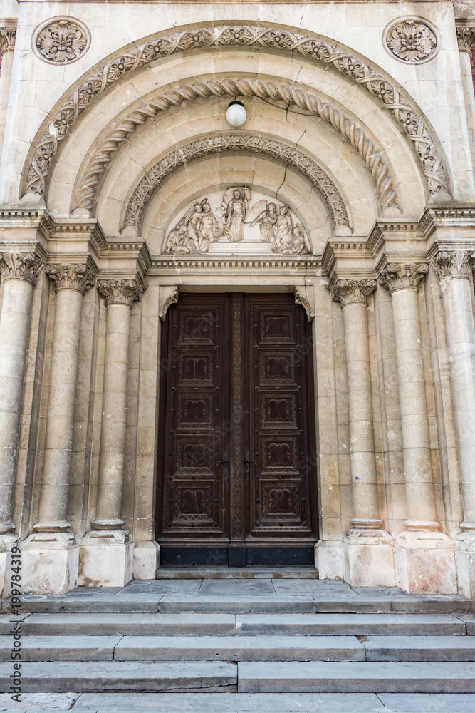 View of the beautiful portal with the old, massive, carved, wooden door of the Cathedral or Basilica of Saint Peter in city of Djakovo in east Croatia
