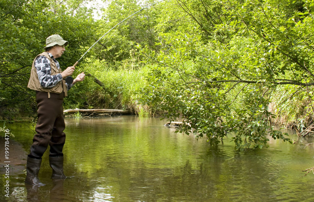 Flyrod fisherman fishing a trout stream Flyrod fisherman fishing a trout stream