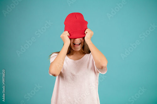 Cuadro en lienzo young Caucasian model wearing white T-shirt is closing her eyes with red cap