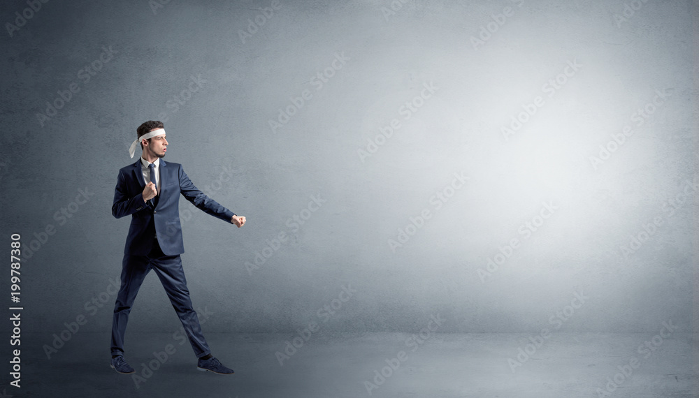 Small karate man fighting in an empty grey copy space Small karate man fighting in an empty grey copy space