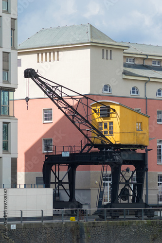 Old yellow crane at the yacht port of rhineauharbor, Cologne, Germany, Rhine promenade, sunny day photo