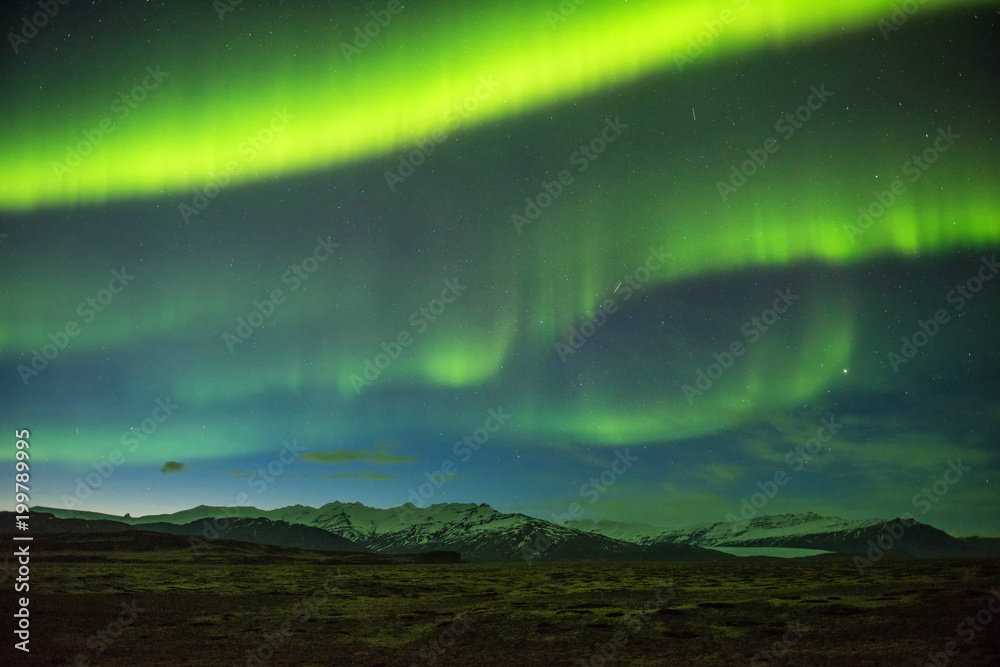 A wonderful night with Kp 5 . Northern lights mountain in Iceland. Background blurred.