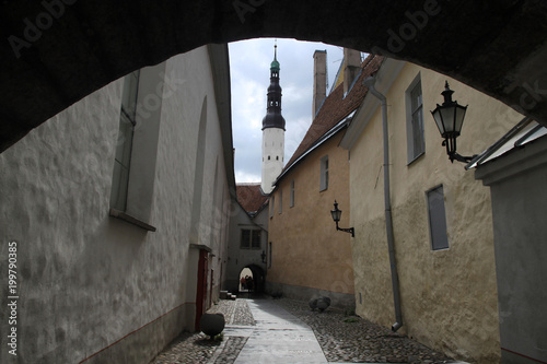 widok z bramy na wąską uliczkę pomiędzy niskimi kamienicami starego miasta w północno wschodniej europie 