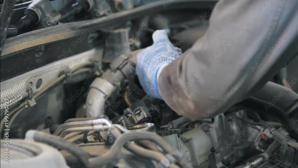 Mechanic in gloves establishing auto parts on the car Mechanic in gloves establishing auto parts on the car