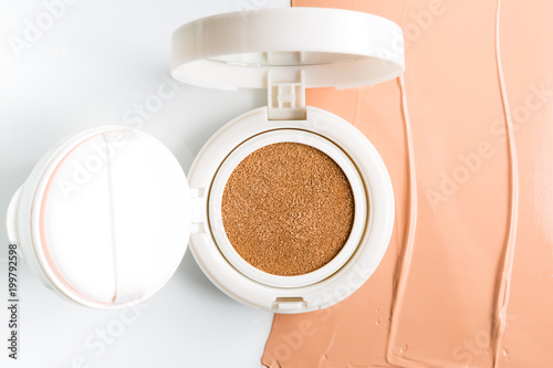 Foundation cushion with sponge and puff on white background.