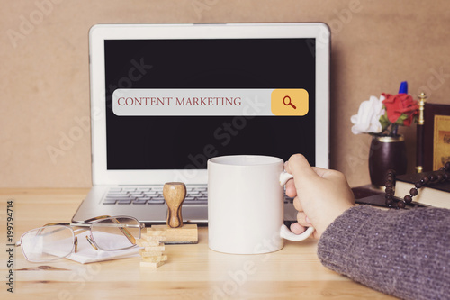 muslim woman drinking a coffee and searching content marketing in search bar