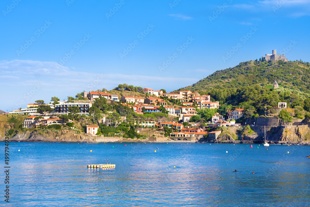 Beach hotels in Collioure village with a windmill at the top of the hill, Roussillon, Vermilion coast, Pyrenees Orientales, France