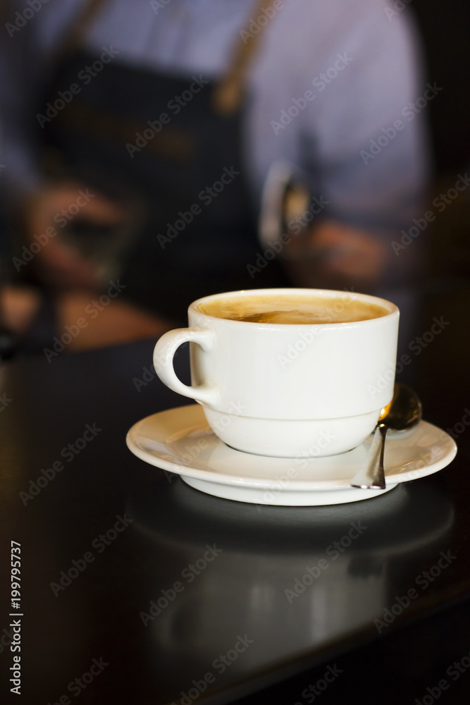 The white Cup of black espresso coffee at the bar counter in cafe