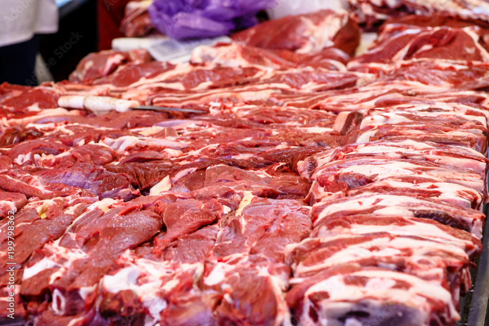 A lot of different meat ( beef, pork, lamb) on the counter in the butcher's shop.