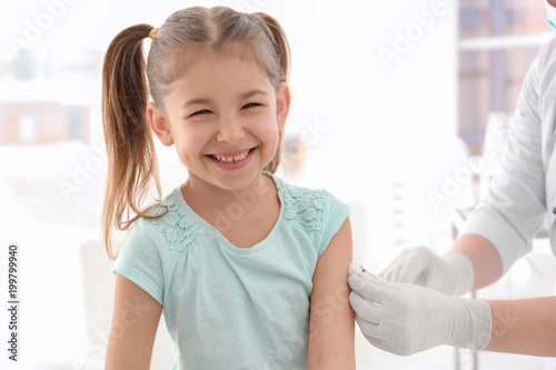 Doctor vaccinating little girl in hospital