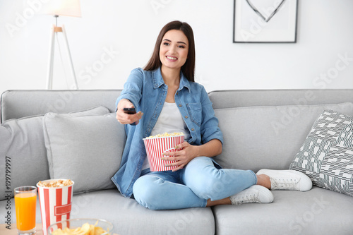 Young woman watching TV on ...