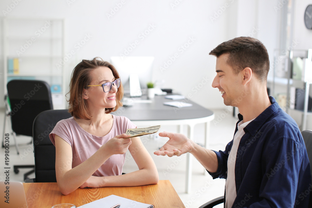 Woman giving money to man in office. Forex concept Woman giving money to man in office. Forex concept
