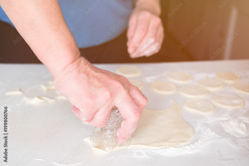 Hands of woman knead the dough on a table, selective focus. Hands of woman knead the dough on a table, selective focus.