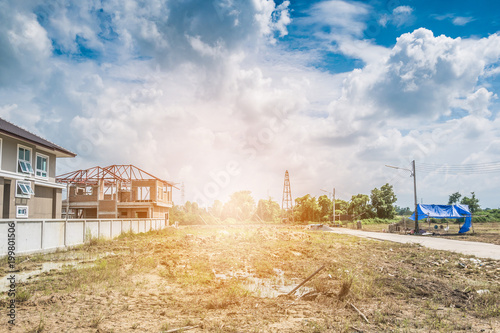 Residential new house building at construction site with clouds and blue sky