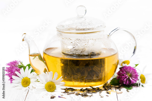 fragrant herbal tea in a teapot on white wooden background, closeup