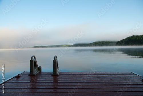 Muskoka dock on a misty morning lake photo