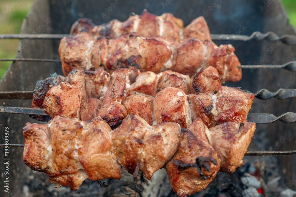 closeup of coocked grilled meat on bbq outdoors.