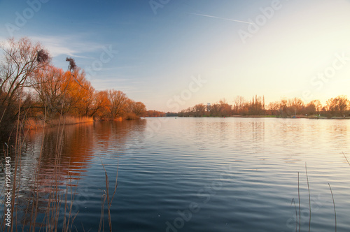 Panorama view of a lake with blue sky and golden sunset light. Südsee in Braunschweig, Germany