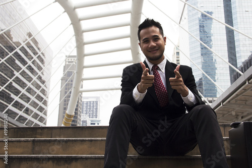 Business man sitting work on street and building background.