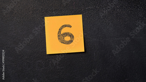 Fotografia Sticky note with number 6 on the blackboard