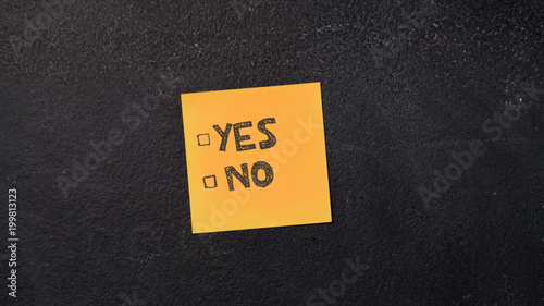 Sticky note with Yes and No boxes on the blackboard