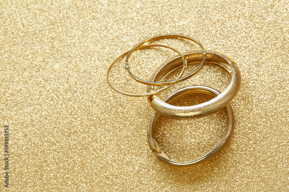 gold jewelry bracelets on gold background Stock Photo | Adobe Stock