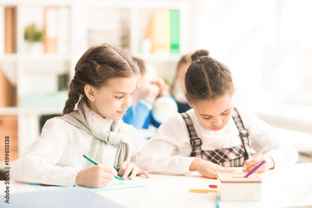 Two little girls drawing together at the table Two little girls drawing together at the table