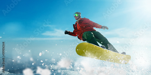 Snowboarder in glasses makes a jump, winter sport