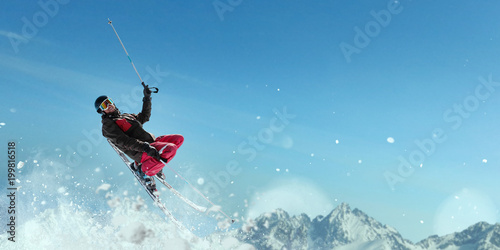 Skier in helmet and glasses makes a jump