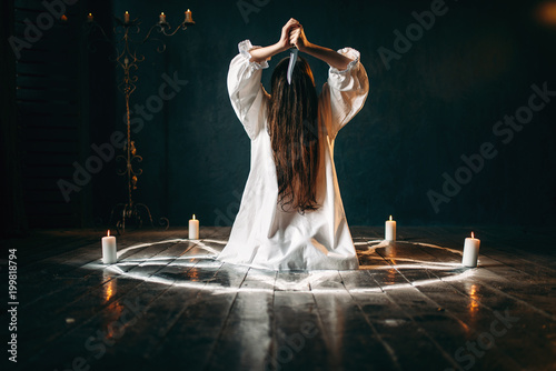 Photo Woman with knife sitting in pentagram circle