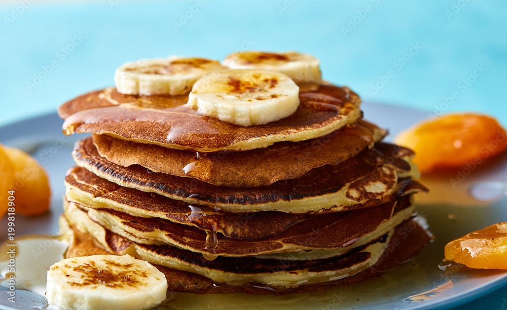 Pile of homemade pancakes with honey and walnuts on rustic wooden background, selective focus Pile of homemade pancakes with honey and walnuts on rustic wooden background, selective focus