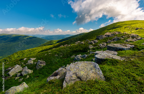 row of huge rocks on a grassy mountain. lovely summer scenery of Carpathian mountains. cloud approaching from behind the hill