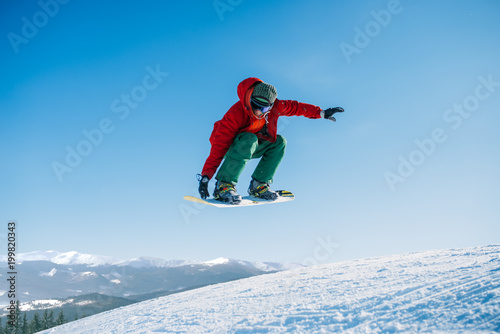 Snowboarder makes a jump on speed slope