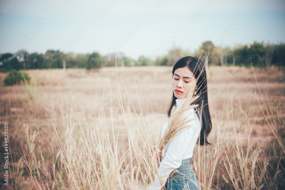 Happy asian woman with beautiful stand on fence at the field,lifestyle of single girl Happy asian woman with beautiful stand on fence at the field,lifestyle of single girl