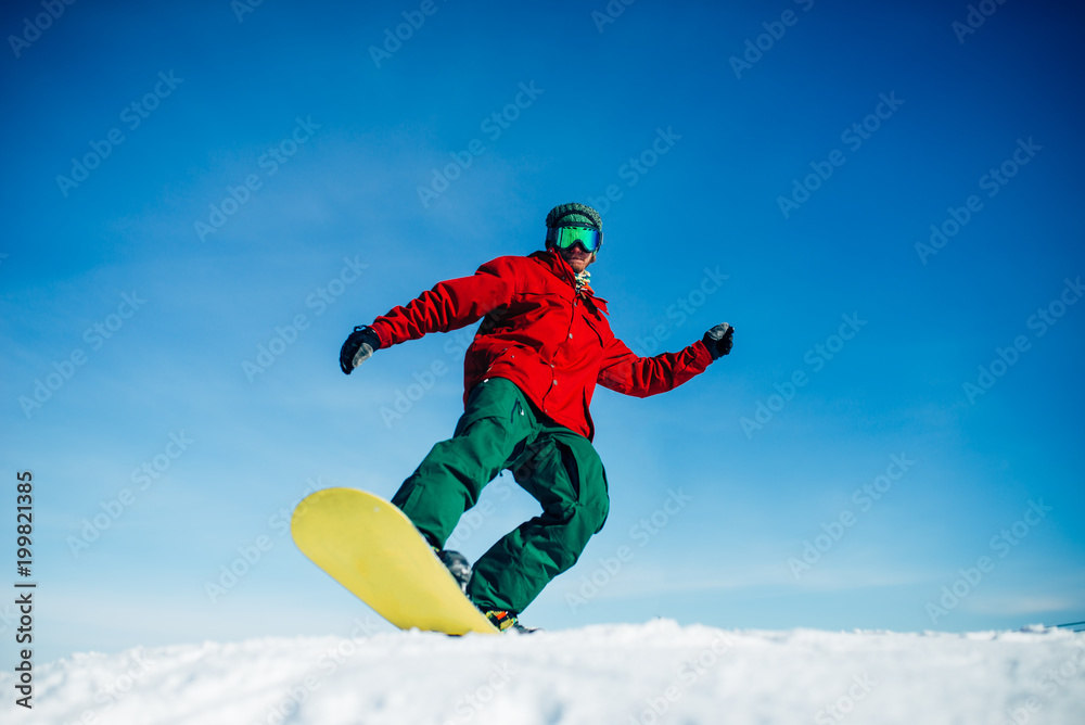 Snowboarder in glasses poses with board in hands